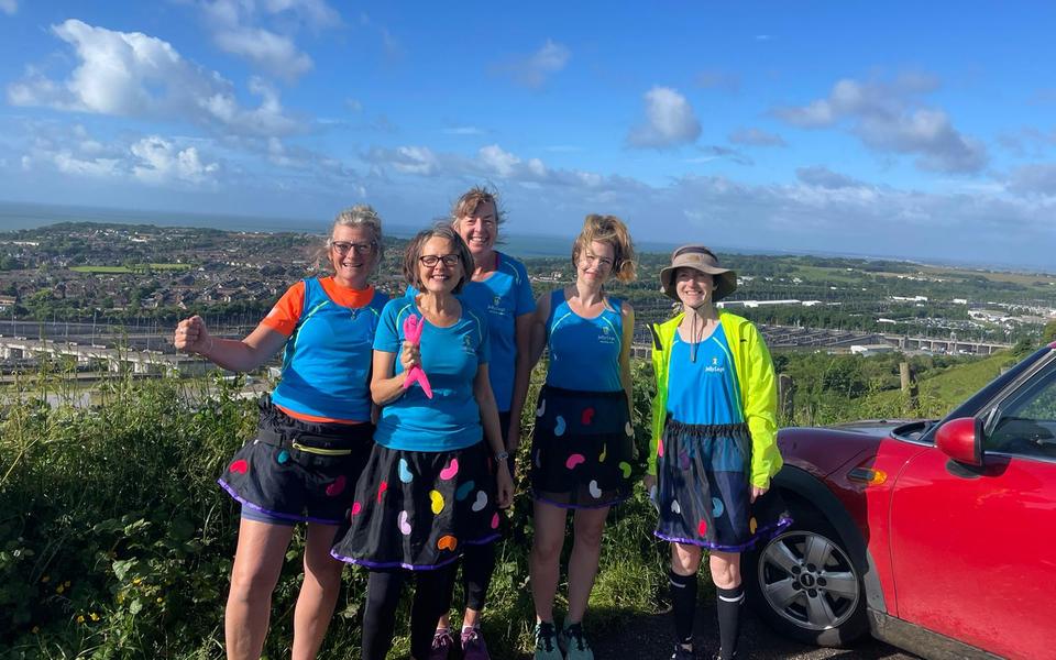 Five Jelly Legs members in their jelly bean skirts at the Saxon Shore Relay, overlooking the coast
